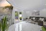 Living room with a tray ceiling, recessed lighting, a glass covered fireplace, and marble finish floors