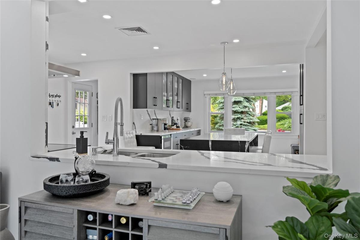 Kitchen featuring gray cabinetry, recessed lighting, pendant lighting, and glass insert cabinets