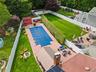 View of pool featuring a fenced backyard, a fire pit, and a storage shed