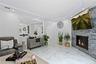 Living room featuring recessed lighting, a fireplace, a raised ceiling, and marble tiled floors