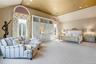 Vaulted ceilings and double exposure create a luxury primary suite with a spa bathroom and generous closet space