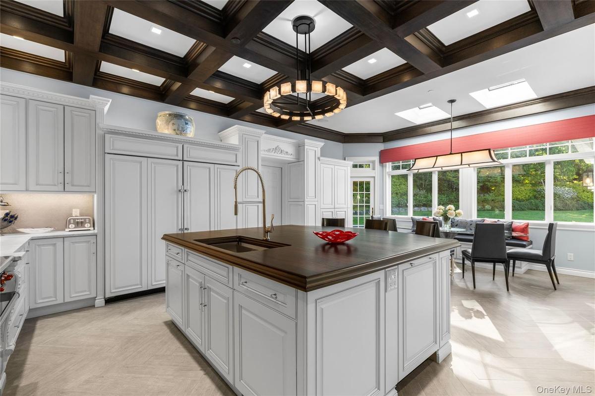Renovated eat in kitchen with dramatic coffered ceilings and butler's pantry with prep area