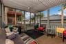 Screened porch featuring a corrugated metal ceiling, wood-frame screens, painted wood railings, and a hard surface floor