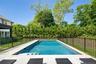 Rectangular inground pool featuring integrated steps and a surrounding patio