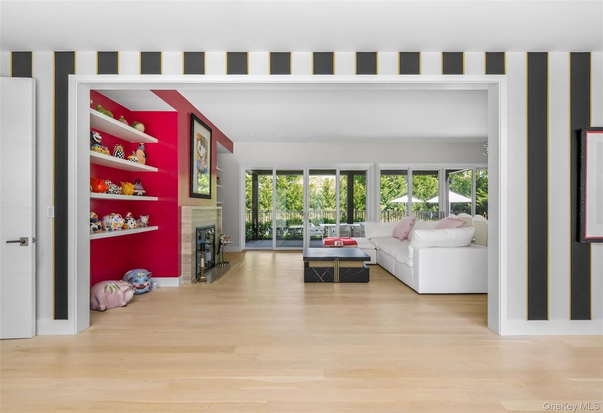Hardwood-finish flooring extending into an open-concept living space with a fireplace and built-in shelving