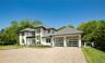 Modern residence featuring a light-colored exterior with dark trim accents