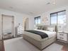 3rd level - Virtually staged spacious owner’s suite featuring a beautifully appointed bath with soaking tub, dual vanities, and remodeled walk-in show