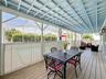 Covered lanai with upgraded wood flooring / wood ceiling accents.
