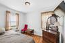Bright interior space featuring a window with blinds, wood-finish flooring, and a ceiling-mounted light fixture