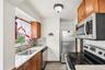 Compact kitchen with wood-finish cabinetry and light-toned countertops