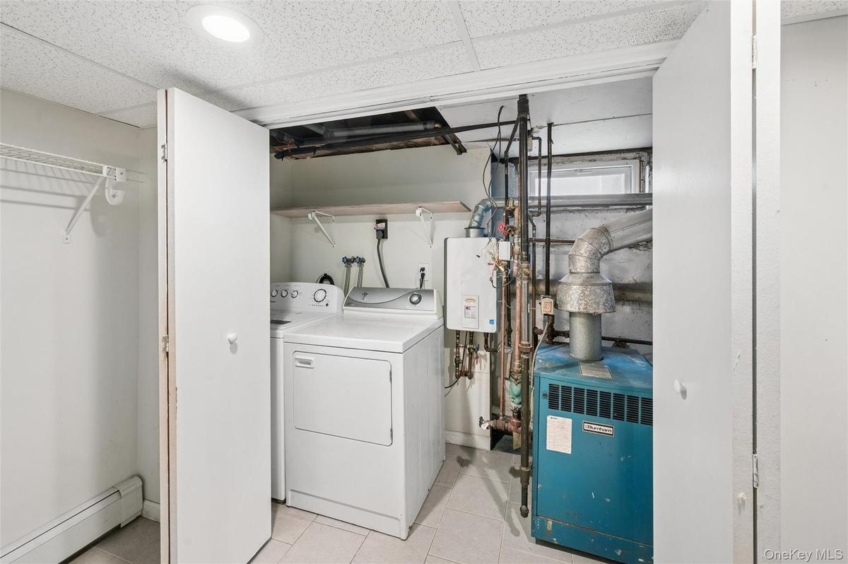 Dedicated utility area featuring a washer and dryer, tiled flooring, and recessed lighting
