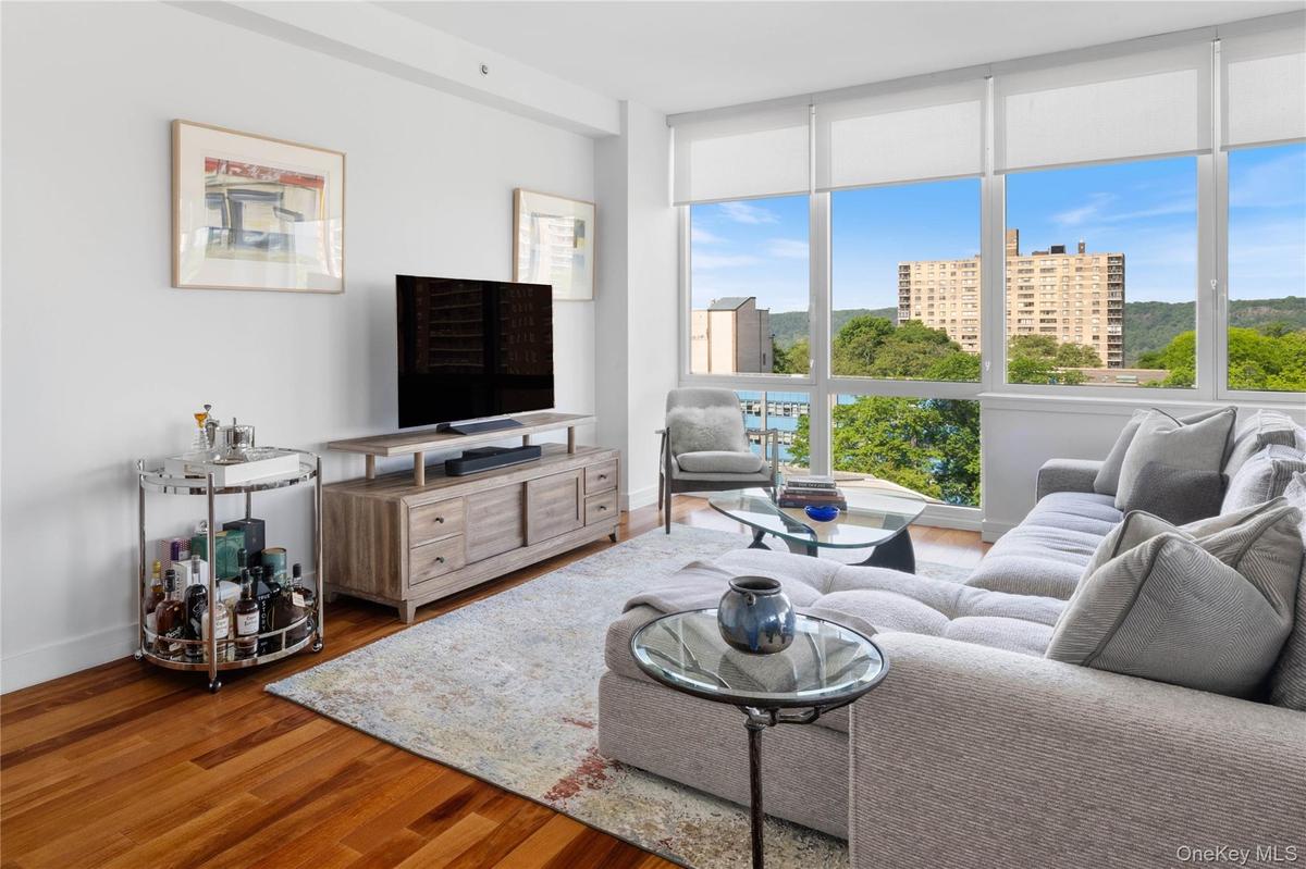 Expansive window wall with roller shades offering scenic distant water and landscape views