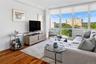 Expansive window wall with roller shades offering scenic distant water and landscape views