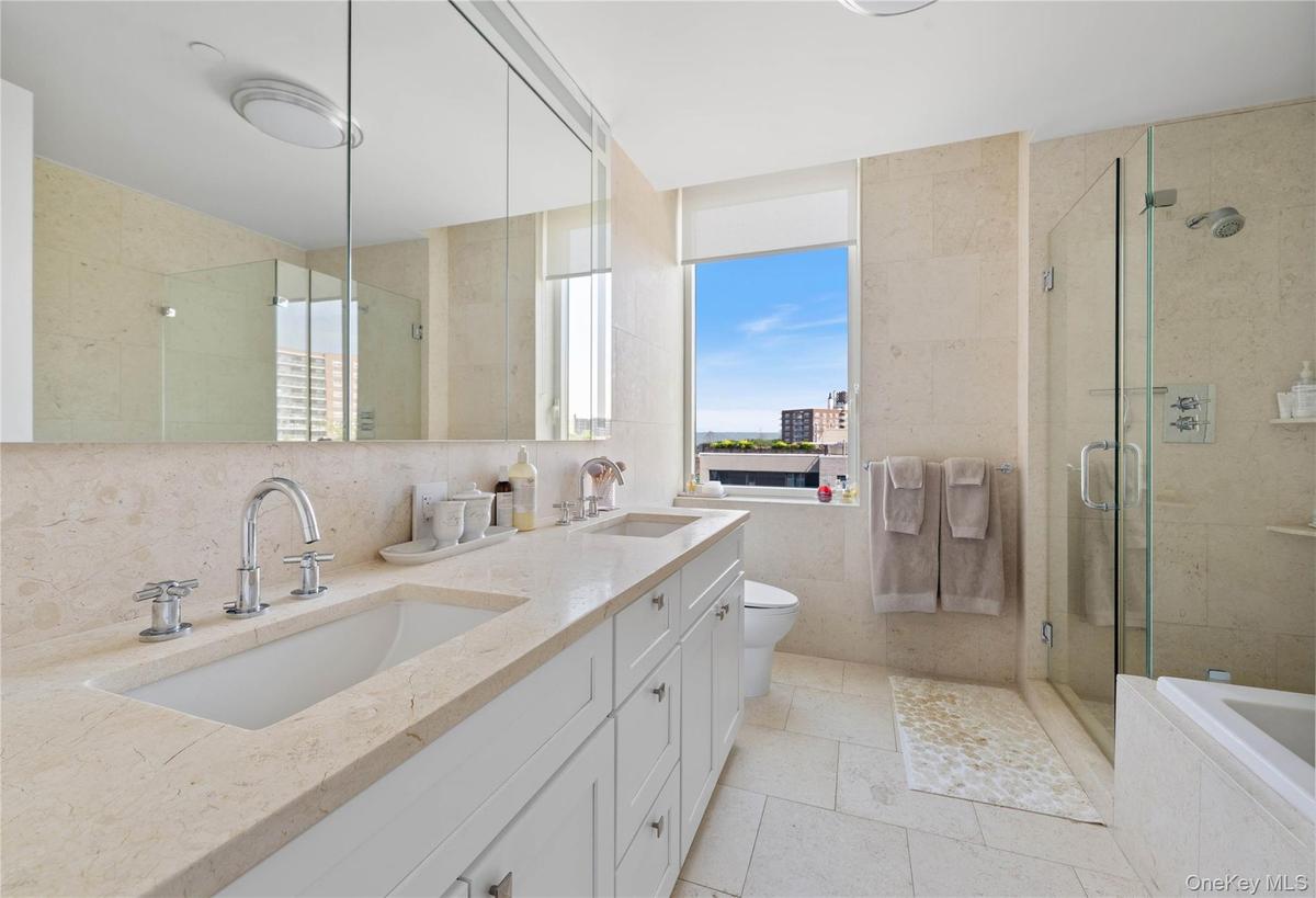 Bathroom featuring a double vanity with integrated sinks, stone-finish countertops, and chrome fixtures