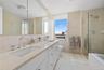 Bathroom featuring a double vanity with integrated sinks, stone-finish countertops, and chrome fixtures