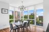 Dining area featuring expansive floor-to-ceiling windows, wood-finish flooring, and a modern sputnik chandelier
