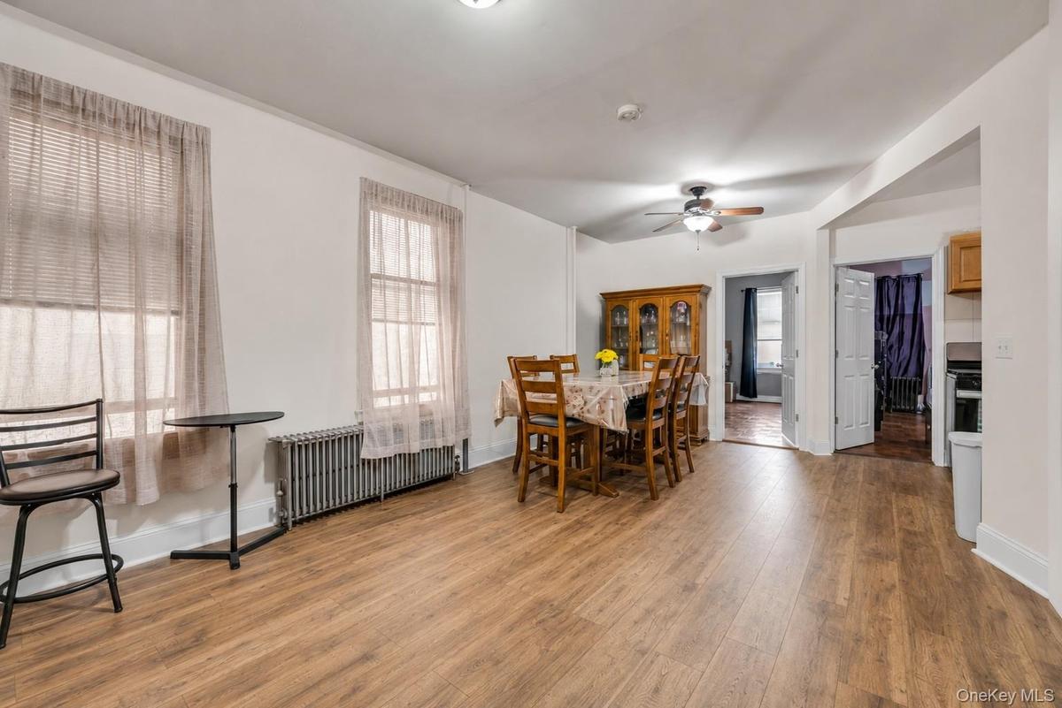 Expansive room featuring wood-finish flooring, white walls, and two windows