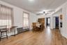 Expansive room featuring wood-finish flooring, white walls, and two windows