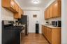 Galley kitchen featuring wood-finish cabinetry, light countertops, and a full-size range with a stainless steel and black finish