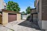 Detached garage with brown panel door and concrete driveway