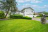 View of front of property featuring a garage and asphalt driveway