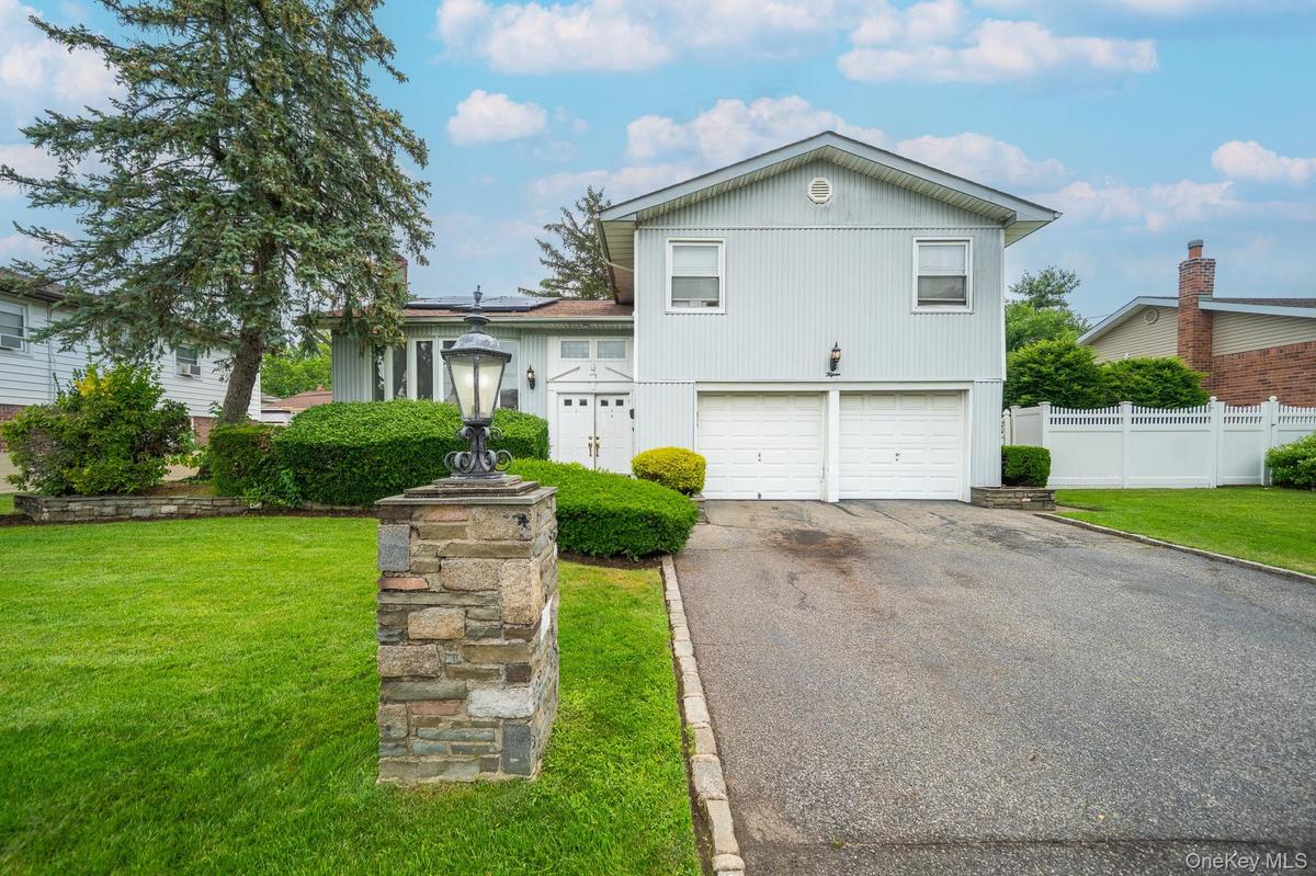 Split level home with asphalt driveway and an attached garage