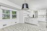 Kitchen featuring white cabinetry, light countertops, white gas cooktop, a peninsula, and baseboards