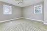 Spare room featuring healthy amount of natural light, carpet flooring, a ceiling fan, and baseboards