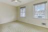 Spare room with light carpet, a ceiling fan, and baseboards