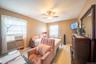Bedroom with light wood-style floors, a ceiling fan, and cooling unit