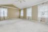 Unfurnished room featuring ceiling fan, plenty of natural light, lofted ceiling, and carpet floors