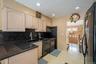 Kitchen with black appliances, light brown cabinets, tasteful backsplash, light wood-style floors, and recessed lighting