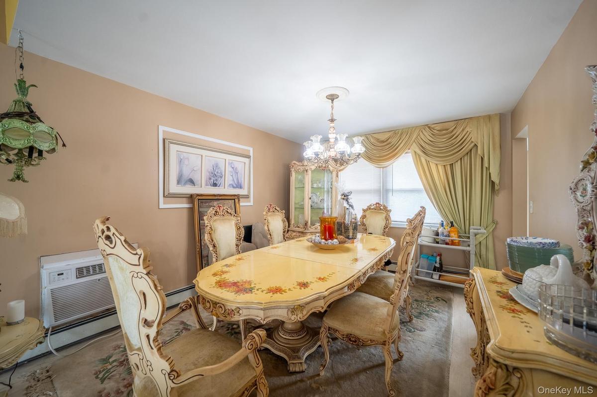 Dining area with carpet, a chandelier, and a baseboard heating unit