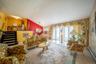 Living area with a baseboard heating unit, vaulted ceiling, a chandelier, and wood finished floors