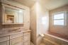 Bathroom with vanity and tile walls