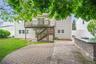 Expansive paver patio featuring a built-in stone veneer outdoor kitchen prep area