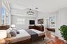 Second Floor Primary Bedroom with full en-suite and large closets with custom cabinets.  Vaulted ceilings accent this room with wood-finish flooring