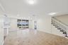 Expansive open-concept room featuring neutral wall tones, large format tile flooring with contrasting accent tiles, and recessed lighting
