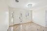 Entryway featuring a white paneled door with decorative sidelights, a tiered crystal chandelier, light-toned tiled flooring with dark accent tiles