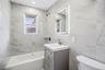 Bathroom featuring a light gray vanity, integrated sink, and an illuminated mirrored medicine cabinet