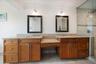 Primary bathroom has dual vanities, walk-in shower.