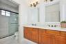 large full bath upstairs with double sink vanity and pocket door into toilet/shower room