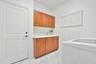 laundry room with cabinets on both sides; retractable drying racks for delicate items