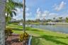 grassy lawn behind screened lanai with lovely canal views