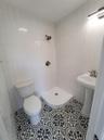 Bathroom featuring tile patterned flooring, tile walls, and walk in shower
