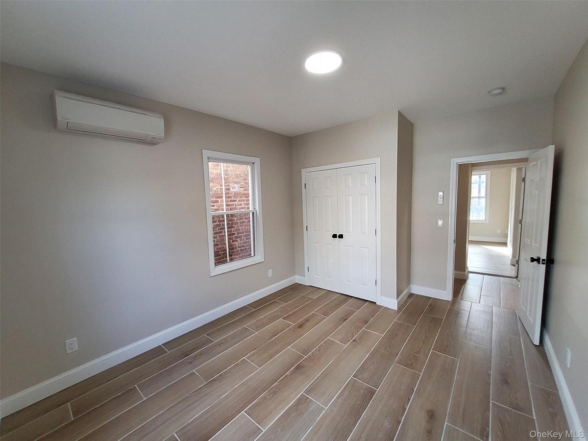 Spare room featuring an AC wall unit and light hardwood / wood-style flooring