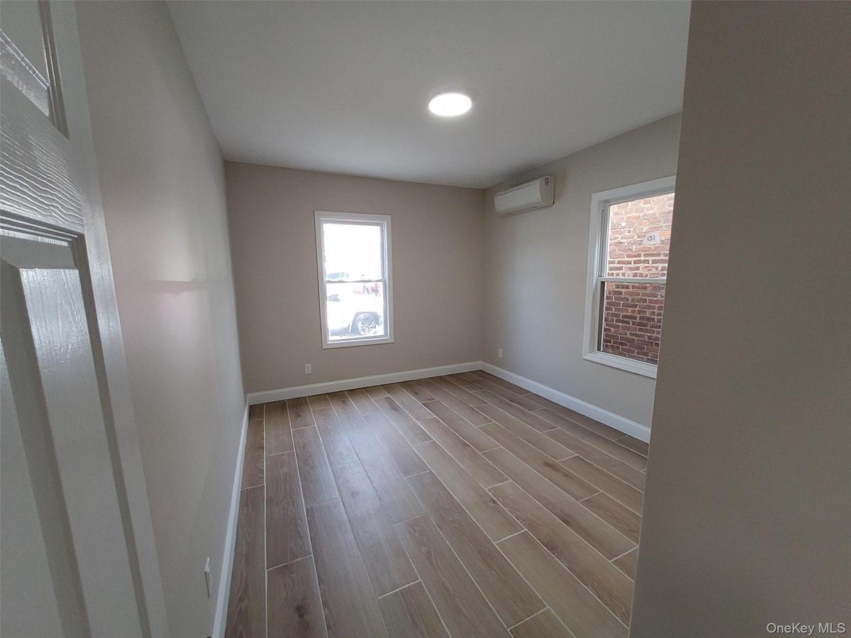 Spare room featuring an AC wall unit and light hardwood / wood-style floors