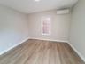 Unfurnished room featuring an AC wall unit and light hardwood / wood-style floors