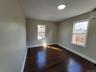 Empty room with a wall mounted air conditioner and dark hardwood / wood-style floors