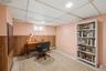 Finished lower level space featuring wood-finish wainscoting, recessed lighting, a drop ceiling, and a window